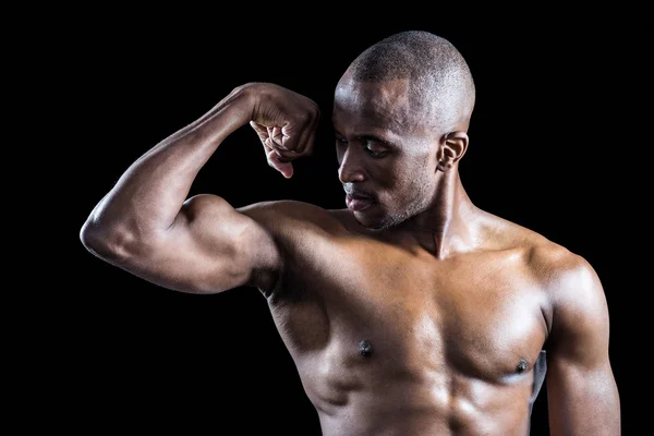 Muscular man looking at bicep — Stock Photo, Image