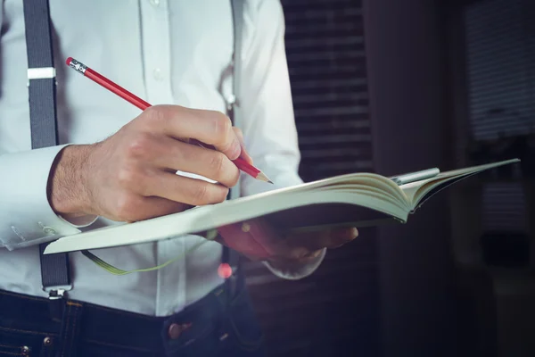 Hombre escribiendo en su bloc de notas en la oficina — Foto de Stock