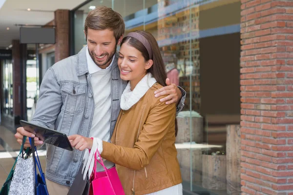 Couple looking at tablet in front of store — Stock Photo, Image