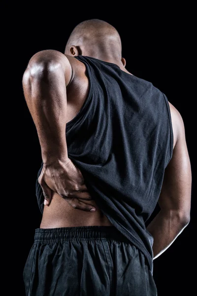 Muscular athlete suffering through back pain — Stock Photo, Image