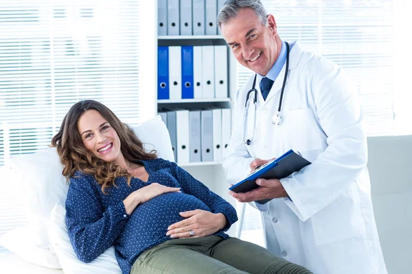 Médico masculino e mulher grávida na clínica — Fotografia de Stock