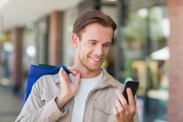 Man använder sin telefon på mall — Stockfoto