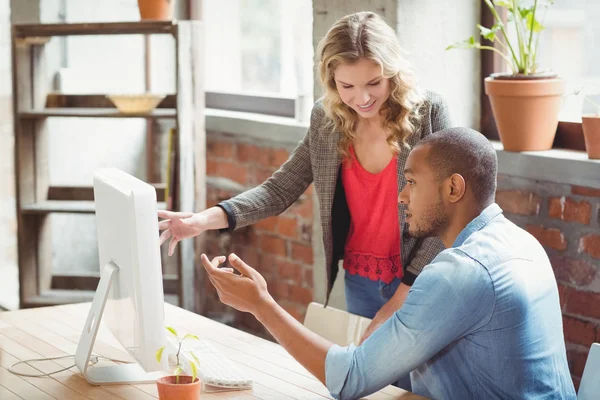 Mann und Frau zeigen auf Computer — Stockfoto