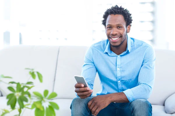 Uomo sorridente che tiene smartphone — Foto Stock