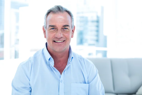 Sorrindo homem sentado em casa — Fotografia de Stock