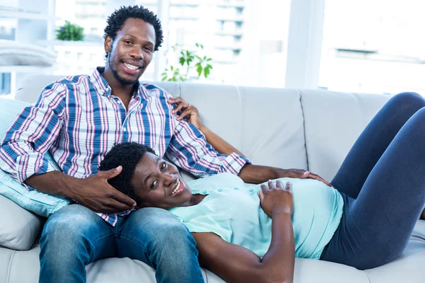 Schwangere Frau entspannt sich auf dem Schoß ihres Mannes — Stockfoto