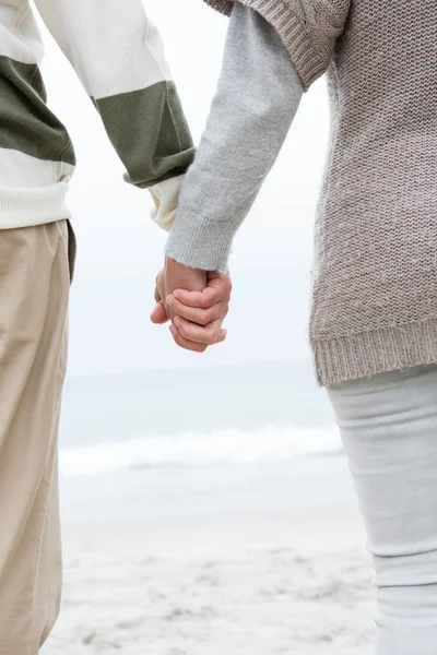 Пара холодных рук на пляже — стоковое фото