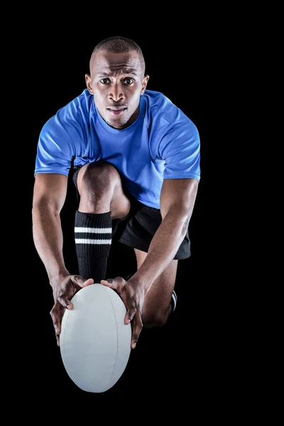 Jogador de rugby ajoelhado e segurando bola — Fotografia de Stock