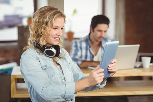 Frau lächelt und schaut auf Tablet — Stockfoto