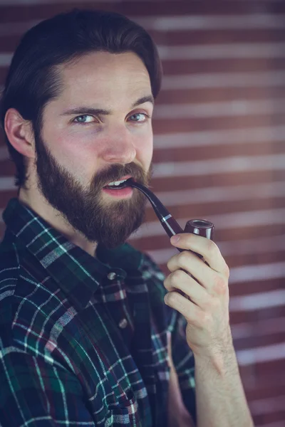 レンガの壁に男喫煙パイプ — ストック写真