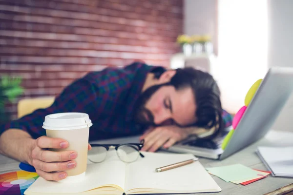 Tired editor holding disposable cup