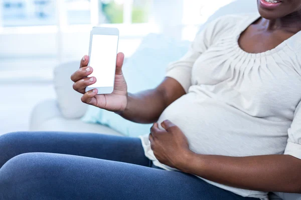 Těhotná žena zobrazeno mobilní telefon — Stock fotografie