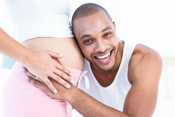 Мужчина слушает живот беременной жены — стоковое фото