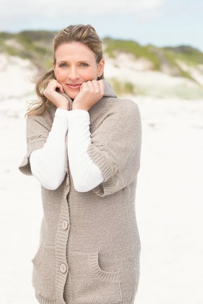 Mujer sonriente de pie sobre la arena —  Fotos de Stock