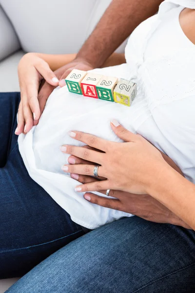 Zwangere buik met speelgoed — Stockfoto