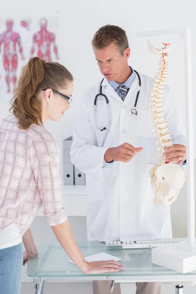 Médico explicando modelo de columna vertebral al paciente — Foto de Stock