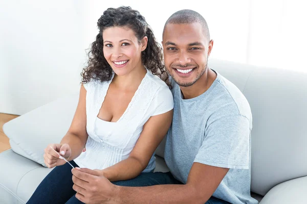 Pareja sentada en sofá en casa — Foto de Stock