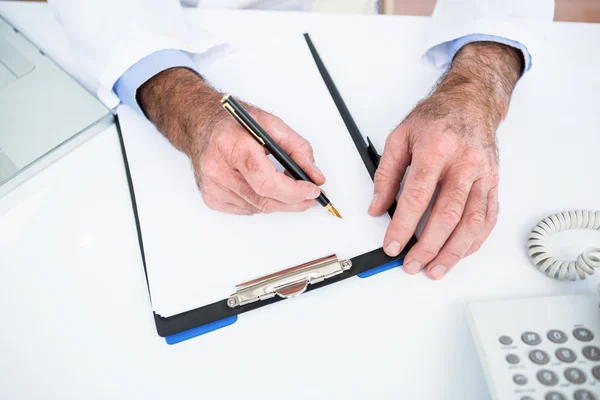 Γιατρός γραψίματος σε χαρτί στην κλινική — Φωτογραφία Αρχείου