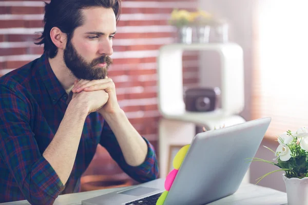 Serious editor with hand clasped using laptop — Stock Photo, Image