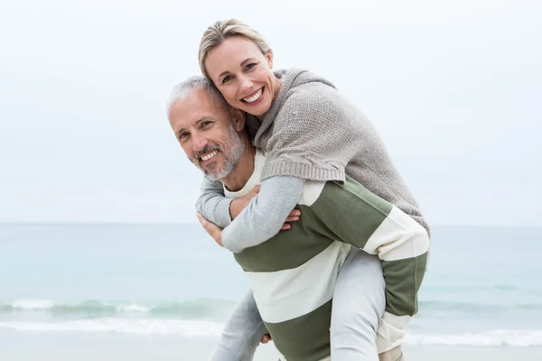 Man ger partner snålskjutsproduktion på stranden — Stockfoto