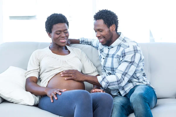 Мужчина с беременной женой трогает живот — стоковое фото