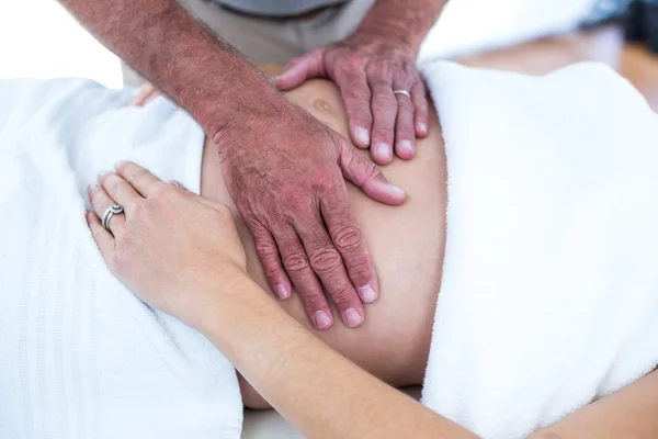 Masseur massaging pregnant woman — Stock Photo, Image