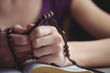 Woman praying with her bible clipart