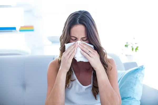 Malade femme éternuer sur canapé — Photo