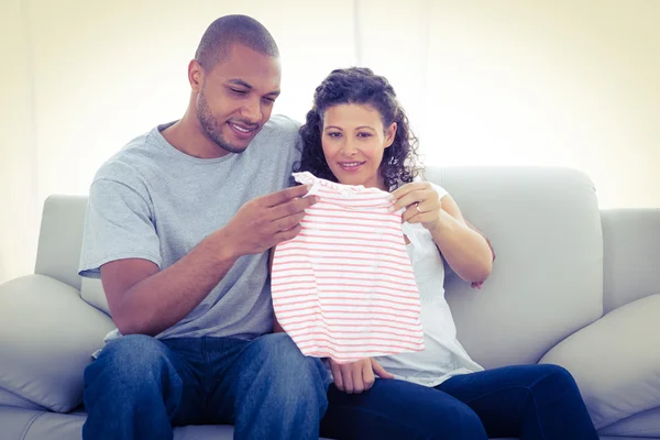 Casal olhando para roupas de bebê — Fotografia de Stock