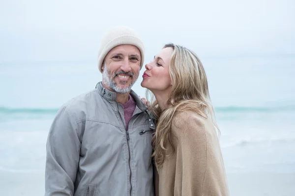 Vrouw te kussen partner bij strand — Stockfoto