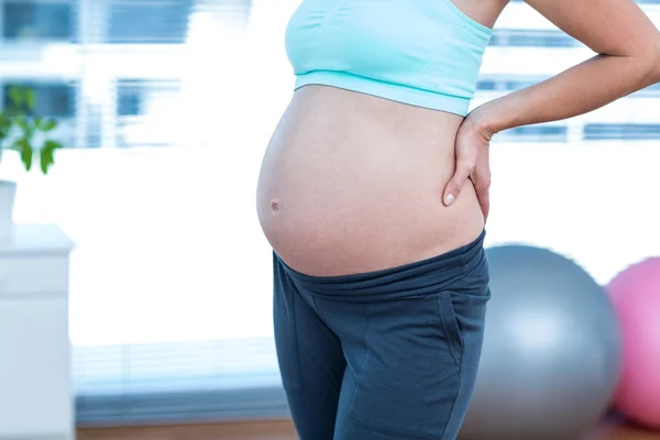 Zwangere vrouw permanent in yoga klas — Stockfoto