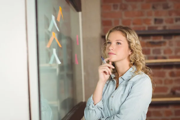 Pensativa mujer de negocios sosteniendo marcador — Foto de Stock