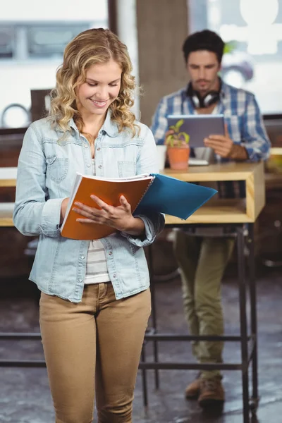 Happy businesswoman looking at file in office — Stock Photo, Image