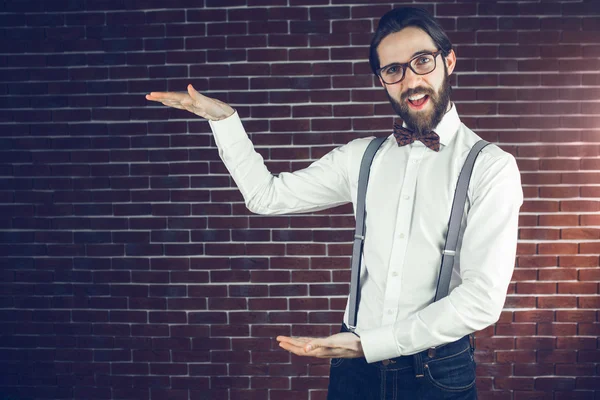 Stylischer Hipster gestikuliert gegen Backsteinmauer — Stockfoto