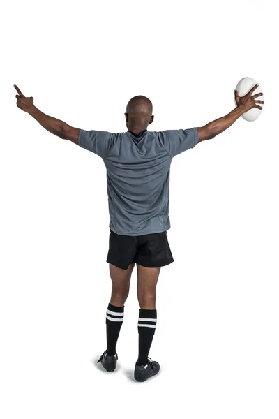 Atleta com braços levantados segurando bola de rugby — Fotografia de Stock