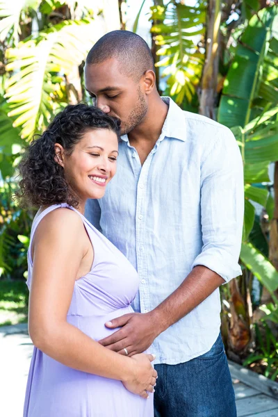Man kysser gravida hustru huvud — Stockfoto