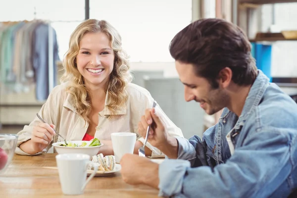 Leende kvinna äter frukost med kollega — Stockfoto