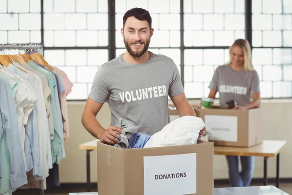 Ehrenamtliche trennen Kleidung von Spendenbox — Stockfoto