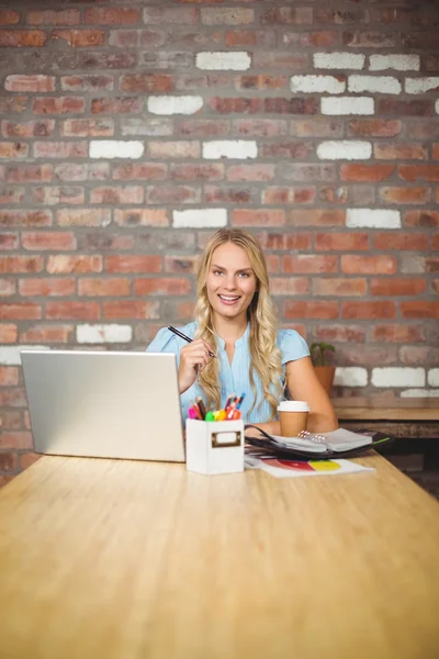 Femme travaillant pendant qu'elle est assise au bureau — Photo