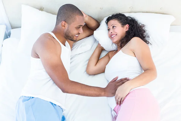 Femme enceinte couchée sur le lit avec son mari — Photo