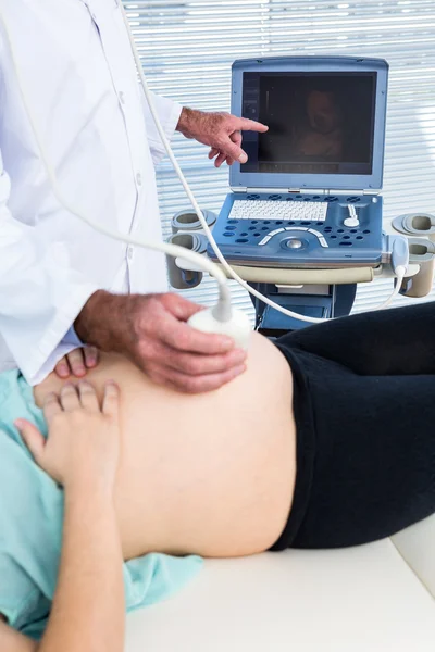 Médico mostrando ultrasonido a mujer embarazada — Foto de Stock