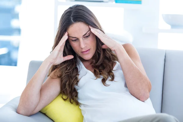 Depressed pregnant woman sitting on sofa — Stock Photo, Image