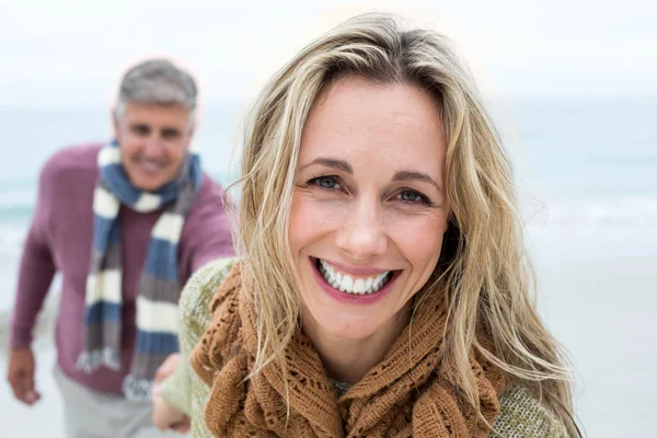 Frau zieht Lebensgefährtin am Strand an — Stockfoto