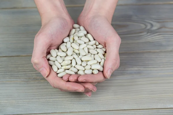 Woman showing handful of lima beans — Stock Photo, Image