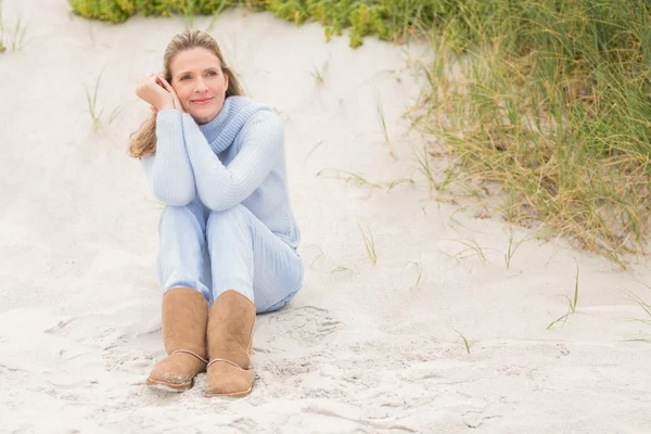 Leende kvinna sitter på sand — Stockfoto