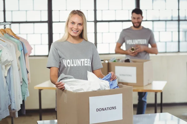 Woman separating clothes from donation box — Stock Photo, Image