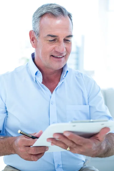 Empresario leyendo bloc de notas mientras está sentado —  Fotos de Stock