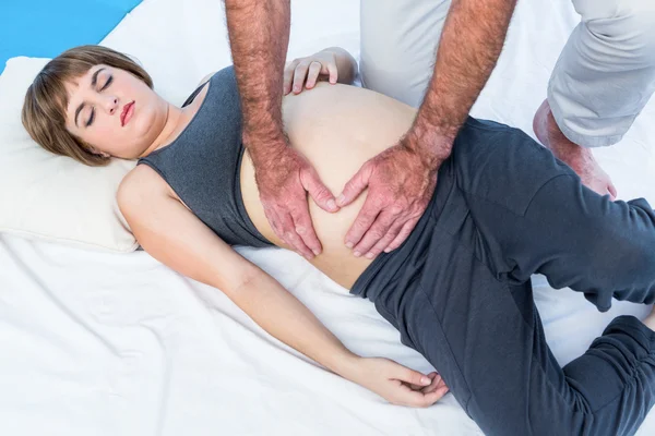 Fizjoterapeuta daje masaż do kobiety w ciąży — Zdjęcie stockowe