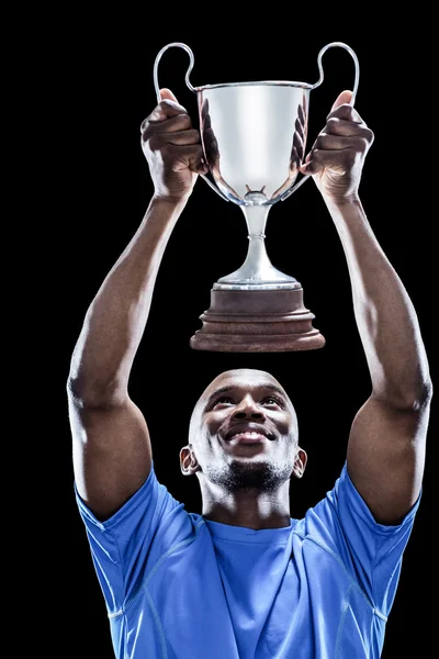 Sportsman looking up while holding trophy — Stock Photo, Image