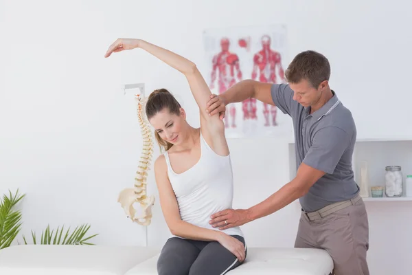 Läkare stretching kvinna arm — Stockfoto